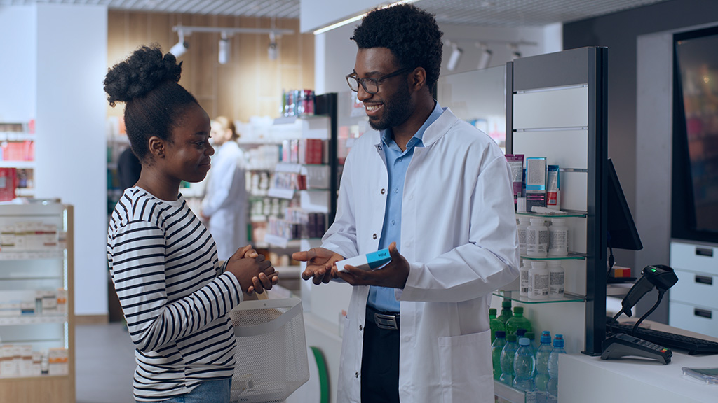 Pharmacy customer buying medication advice medical consultation doctor pharmacist health care service drugs prescription African American man woman in drugstore medical assisting client order medicine.