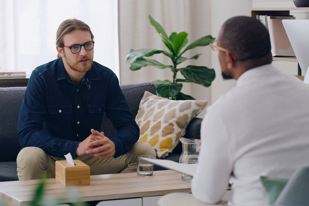 A man talking to a medical professional at his behavioral services appointment.