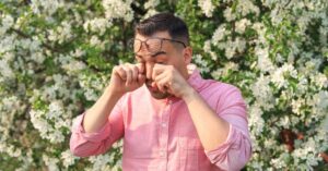 A man suffers from allergies and wipes his watery eyes stock photo